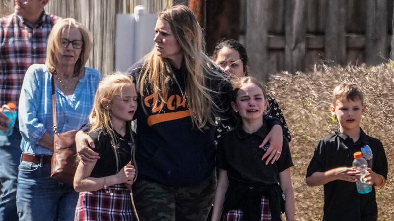 Children and a woman depart the reunification center at the Woodmont Baptist church after a...